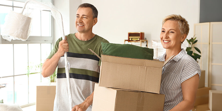 Couple portant des cartons de déménagement